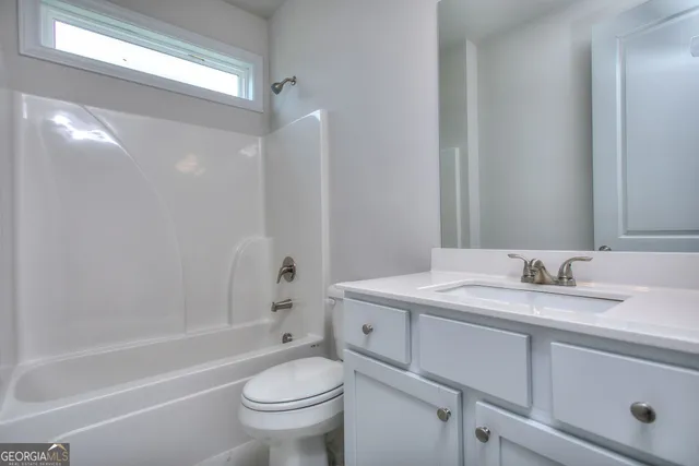 a bathroom with a granite countertop sink toilet mirror and bathtub