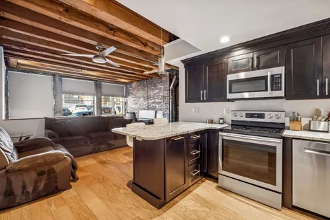 a open kitchen with stainless steel appliances granite countertop a stove and a sink