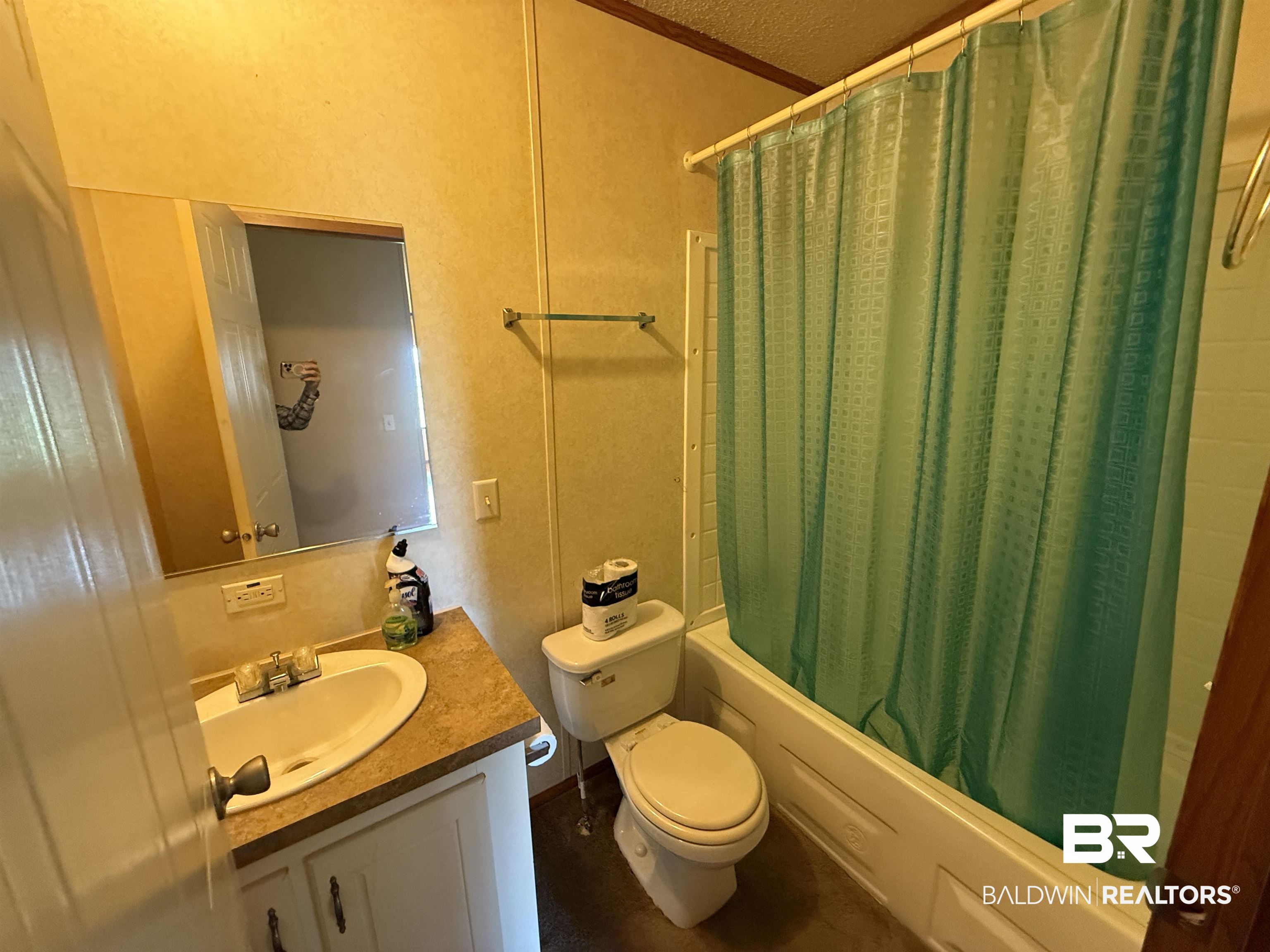 14402 County Road 55 Foley, AL 36535 - Photo 17 of 20 Full bathroom featuring a textured ceiling, toilet, shower / bath combo with shower curtain, ornamental molding, and vanity