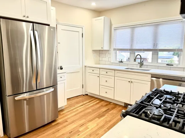 a kitchen with a refrigerator stove and white cabinets