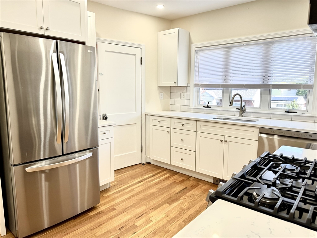 a kitchen with a refrigerator stove and white cabinets