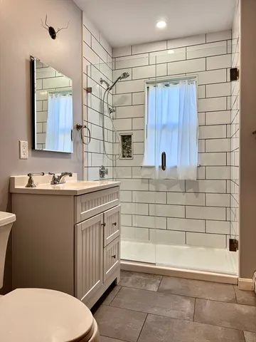 a bathroom with a sink a toilet and shower
