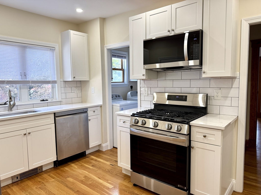 57 Winthrop Road, Unit 2 Everett, MA 02149 - Photo 2 of 15 a kitchen with stainless steel appliances a stove a microwave a sink and cabinets