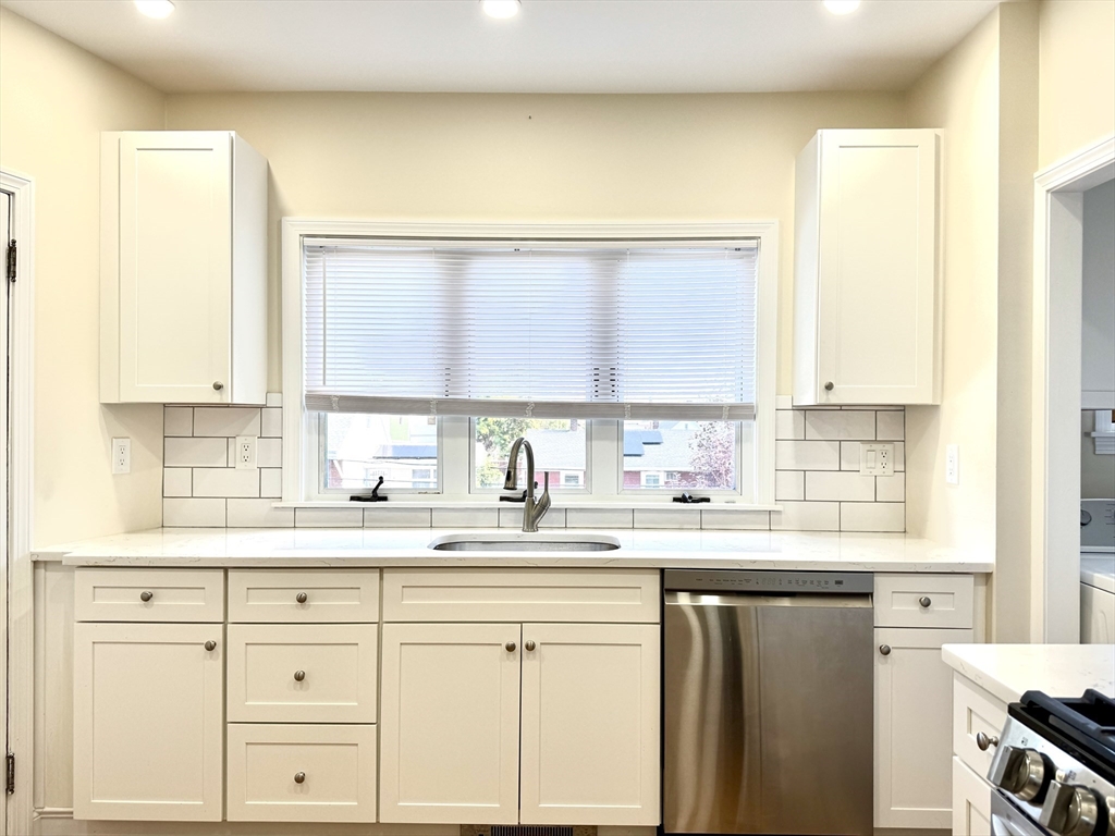 57 Winthrop Road, Unit 2 Everett, MA 02149 - Photo 3 of 15 a kitchen with granite countertop white cabinets and a window