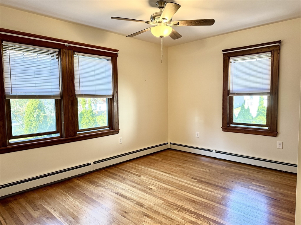 57 Winthrop Road, Unit 2 Everett, MA 02149 - Photo 10 of 15 a view of an empty room with a window and wooden floor