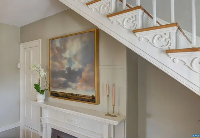 a living room with a large window couches and kitchen view