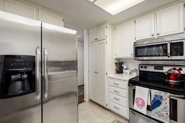a kitchen with white cabinets and white appliances