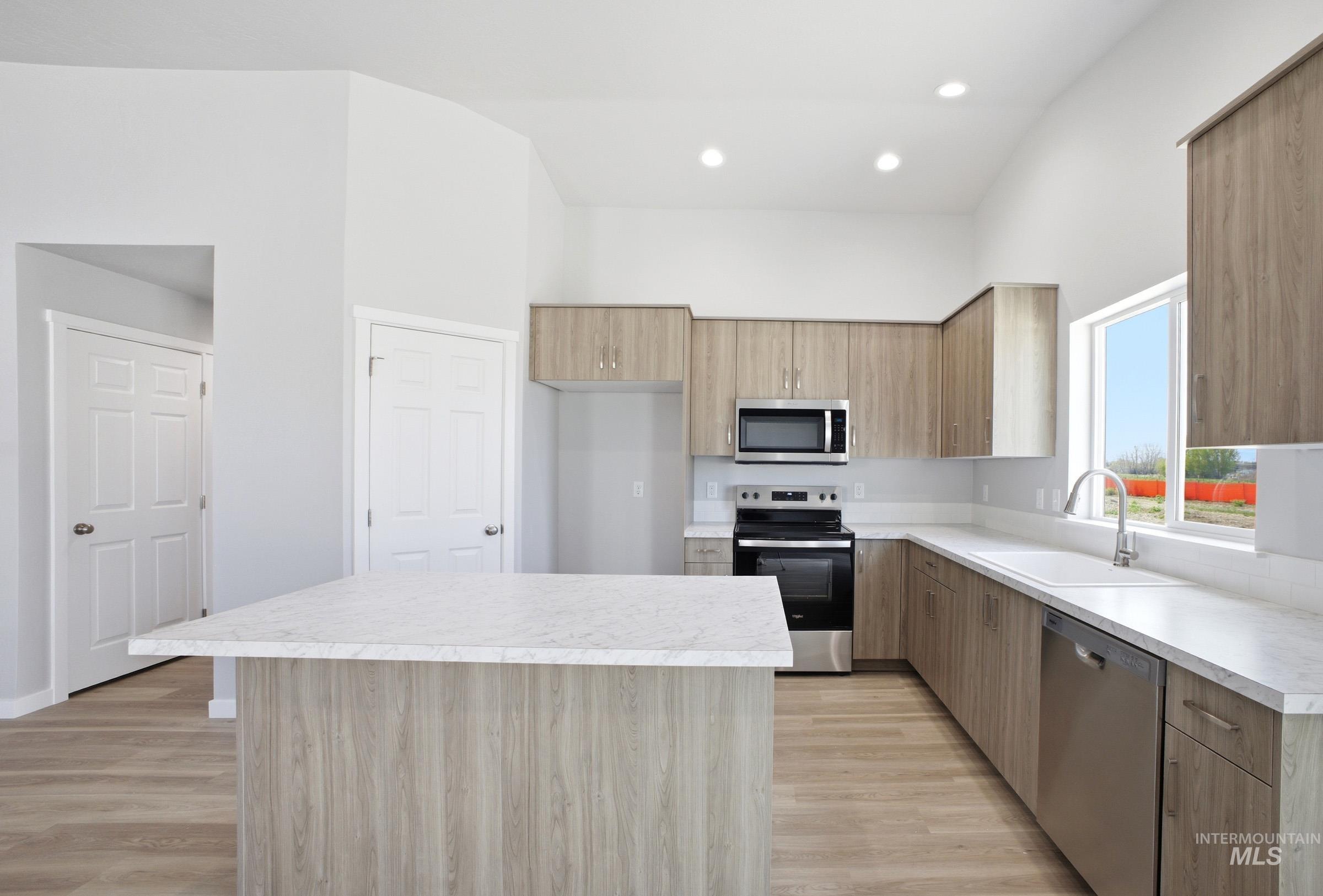 14106 Winding Street Caldwell, ID 83607 - Photo 4 of 18 Kitchen featuring wood-finish cabinetry, stainless steel appliances, a center island with a light-toned countertop, and recessed lighting