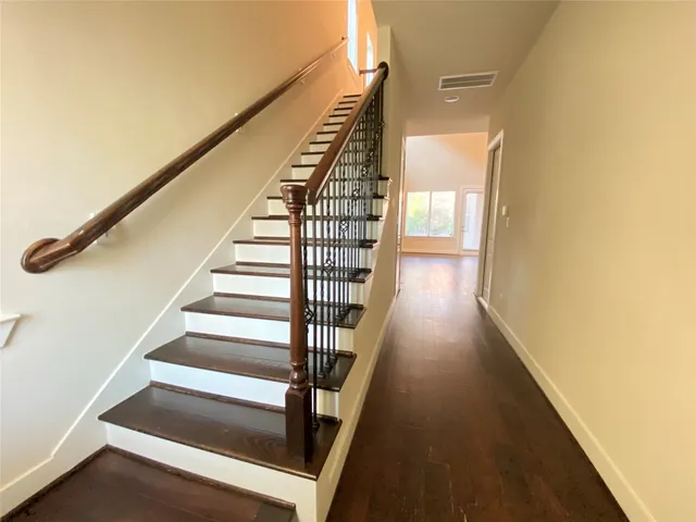 an empty room with a ceiling fan and wooden floor