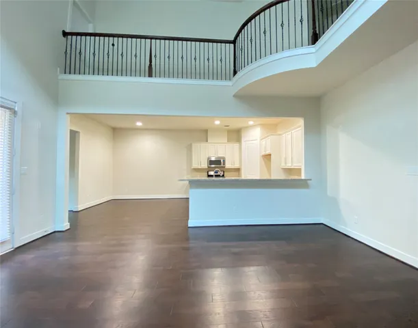 a view of a kitchen with wooden floor and electronic appliances