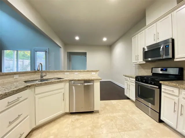 a bathroom with a granite countertop sink a toilet and a mirror