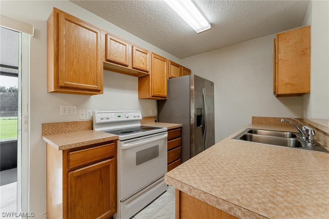 1140 Sealey Road Moore Haven, FL 33471 - Photo 13 of 29 a kitchen with a stove and a refrigerator