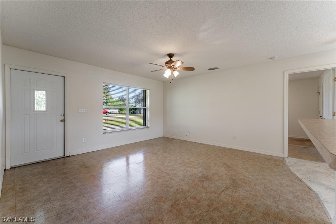 1140 Sealey Road Moore Haven, FL 33471 - Photo 7 of 29 an empty room with windows and chandelier fan