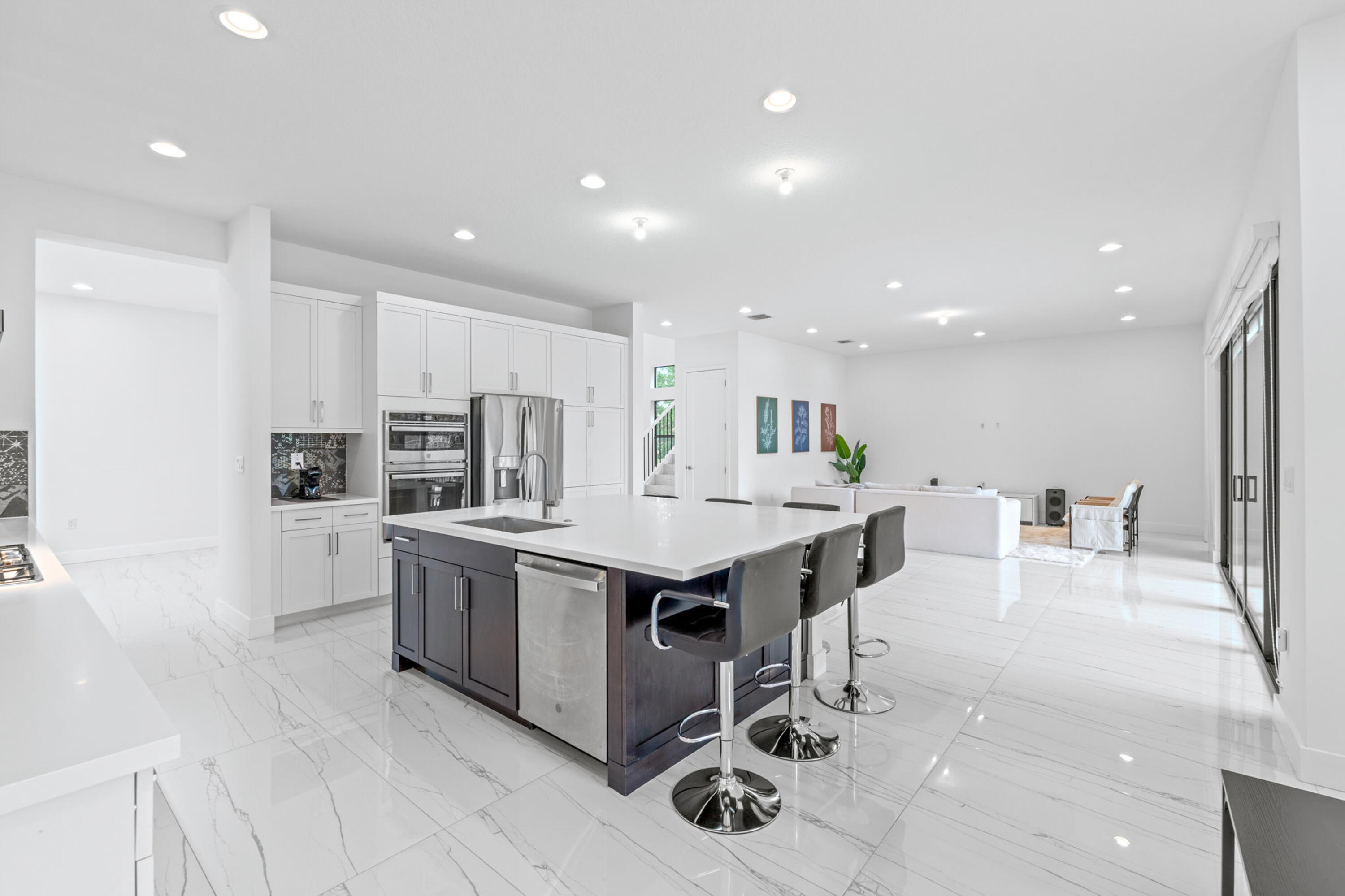 17117 Teton River Road Boca Raton, FL 33496 - Photo 14 of 67 a kitchen with stainless steel appliances kitchen island granite countertop a table chairs sink and cabinets
