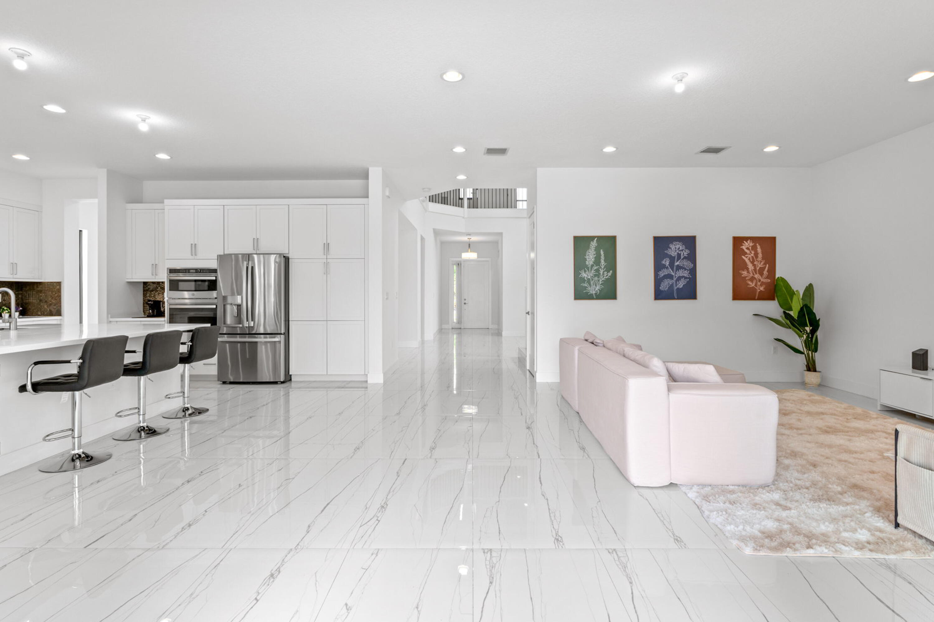 17117 Teton River Road Boca Raton, FL 33496 - Photo 19 of 67 a large white kitchen with stainless steel appliances kitchen island granite countertop a refrigerator and cabinets