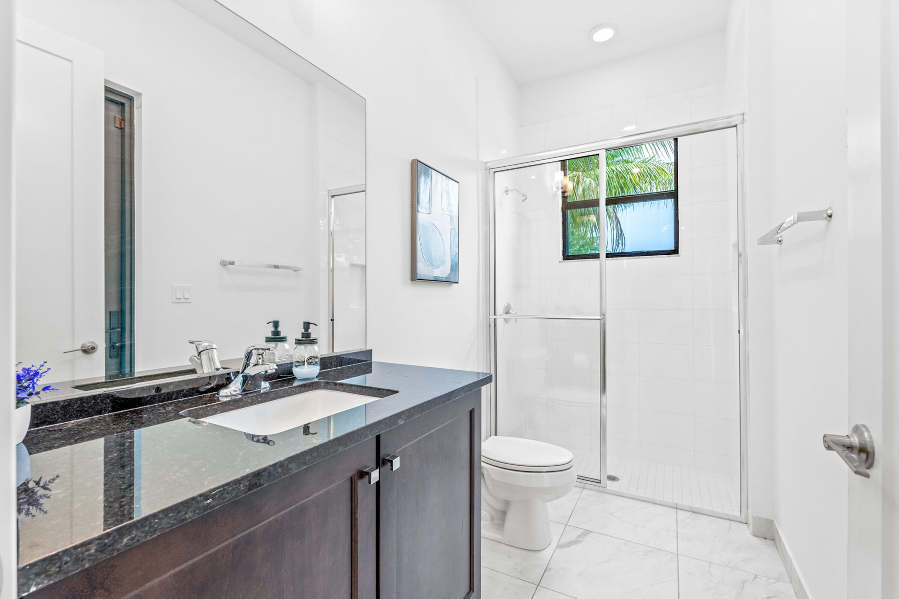 17117 Teton River Road Boca Raton, FL 33496 - Photo 22 of 67 a bathroom with a granite countertop sink a toilet a mirror and shower