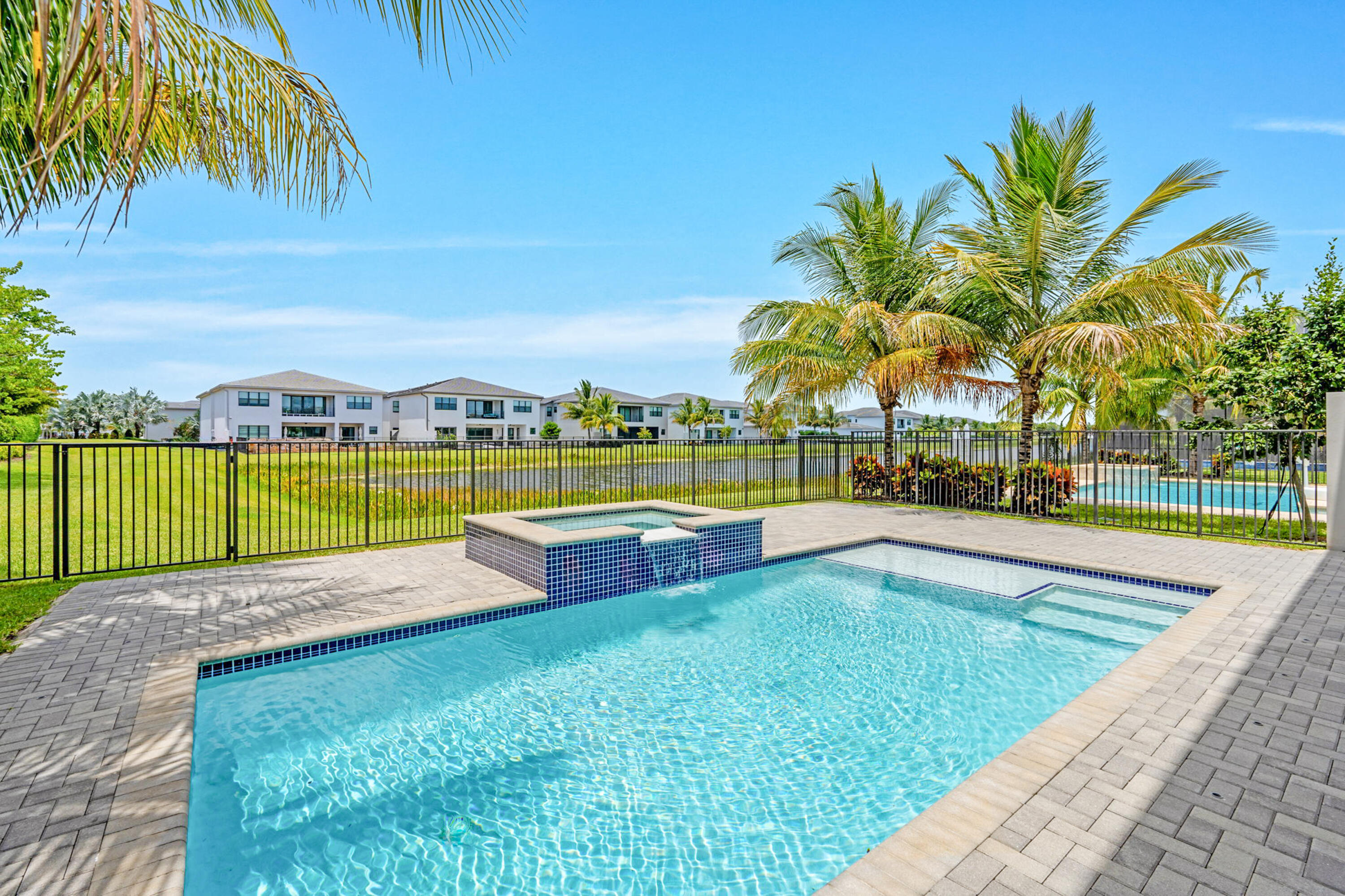 17117 Teton River Road Boca Raton, FL 33496 - Photo 41 of 67 a view of a swimming pool with a lawn chairs under palm trees