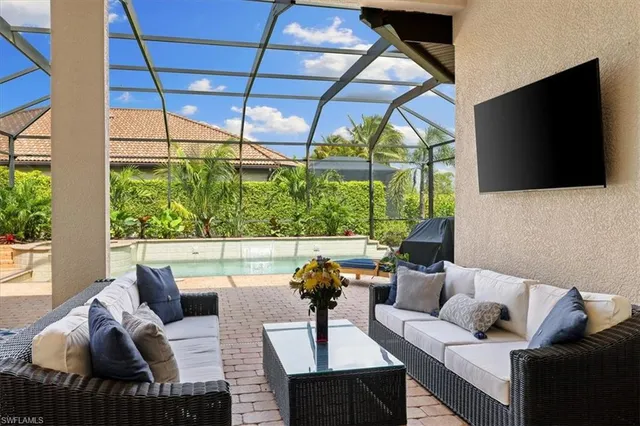 a living room with furniture tv and a floor to ceiling window