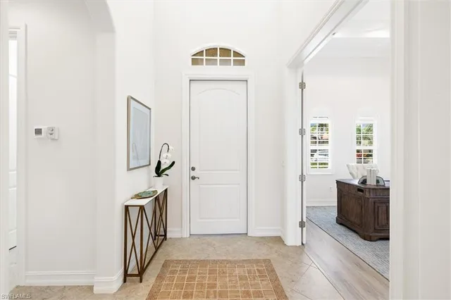 a view of a hallway with wooden floor and a bathroom