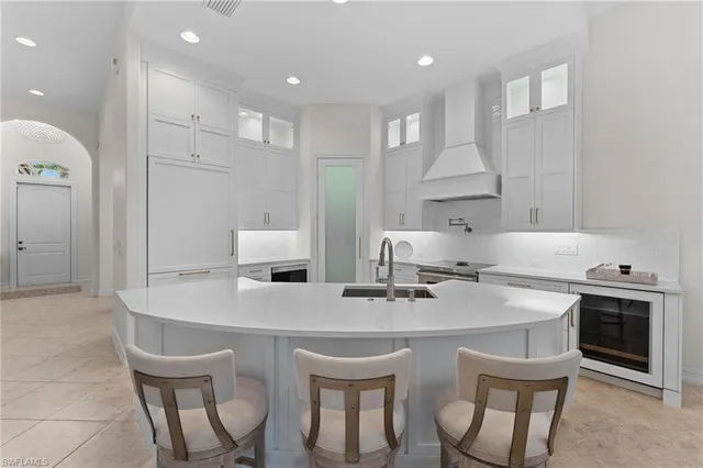 a kitchen with stainless steel appliances a sink table and chairs