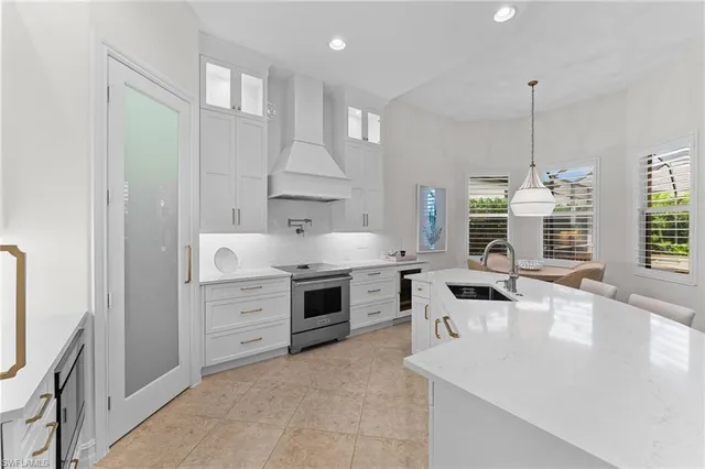 a kitchen with granite countertop a stove a sink and a refrigerator