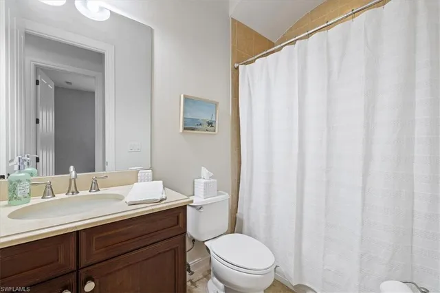 a bathroom with a sink a toilet and shower curtain