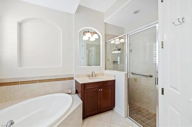 a spacious bathroom with a tub sink and mirror