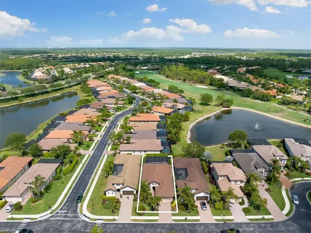 an aerial view of residential houses with outdoor space and lake view