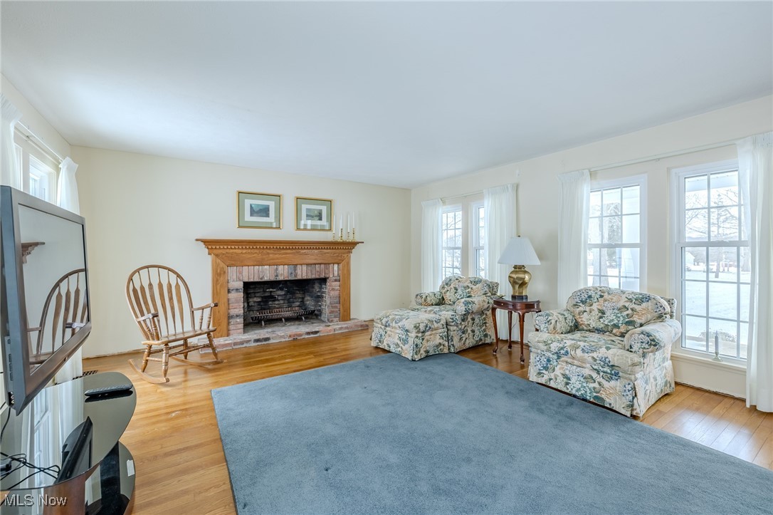 8648 Ravenna Road Chardon, OH 44024 - Photo 11 of 39 Living area with a brick fireplace, a wealth of natural light, and light wood-style floors