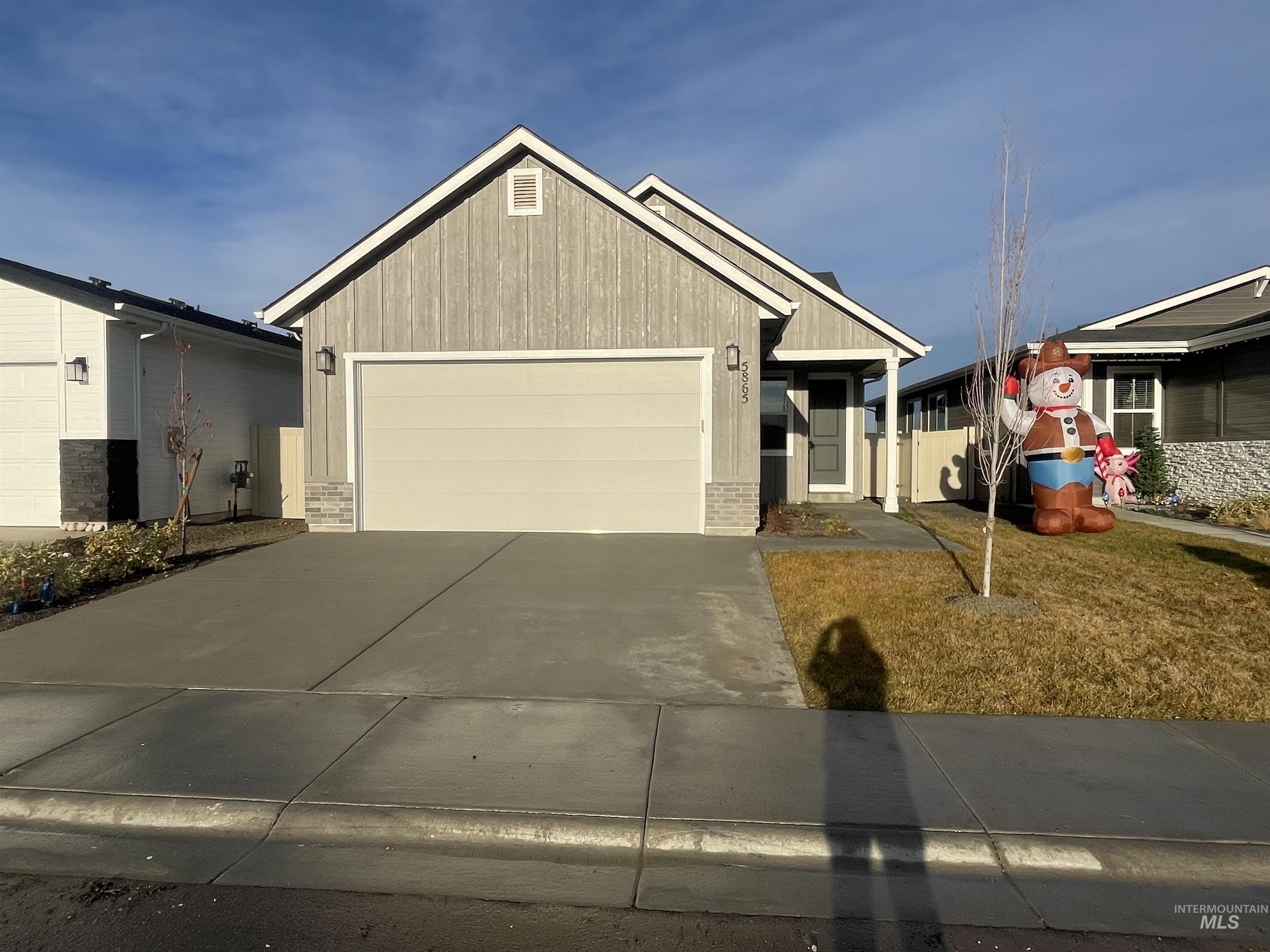 View of front of property featuring driveway, a garage, and brick siding