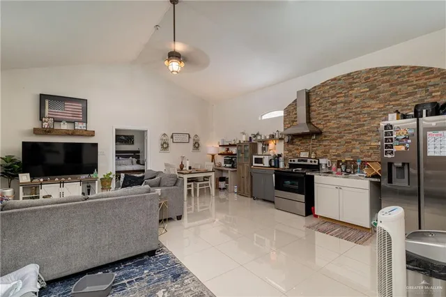 a living room with stainless steel appliances kitchen island granite countertop furniture and a fireplace