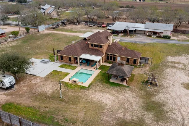 an aerial view of a swimming pool with outdoor seating