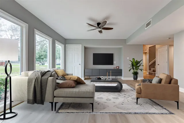 a view of an empty room with a window and wooden floor
