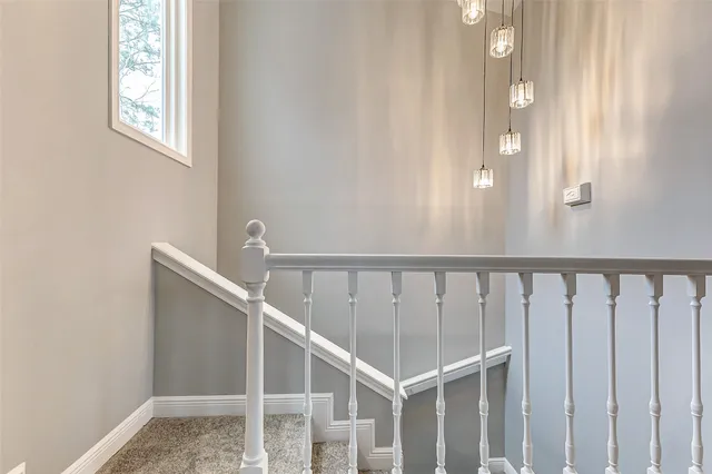 a view of an empty room and chandelier fan