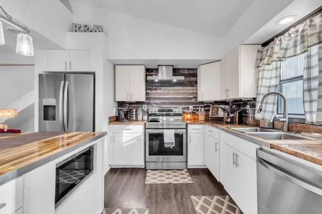 a kitchen with stainless steel appliances granite countertop a stove and a sink