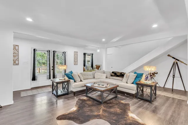 a living room with furniture and a wooden floor