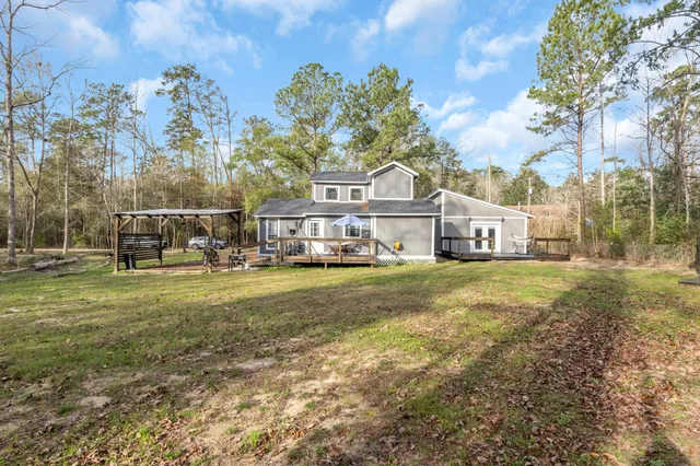 a view of a house with a big yard and large trees