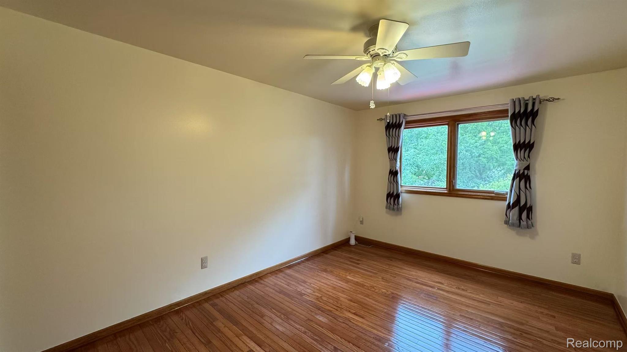 3440 Salem Drive Rochester, MI 48306 - Photo 24 of 33 Bright interior space featuring wood-finish flooring, a ceiling fan with integrated lighting, and a large window with wood trim