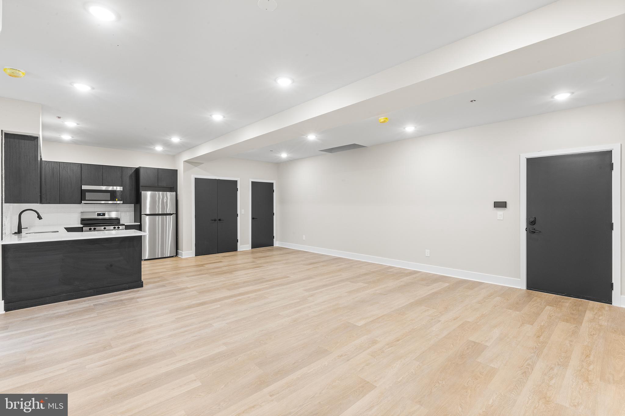 1903 Jackson Street, Unit 1 Philadelphia, PA 19145 - Photo 2 of 17 a large kitchen with kitchen island a sink stainless steel appliances and cabinets