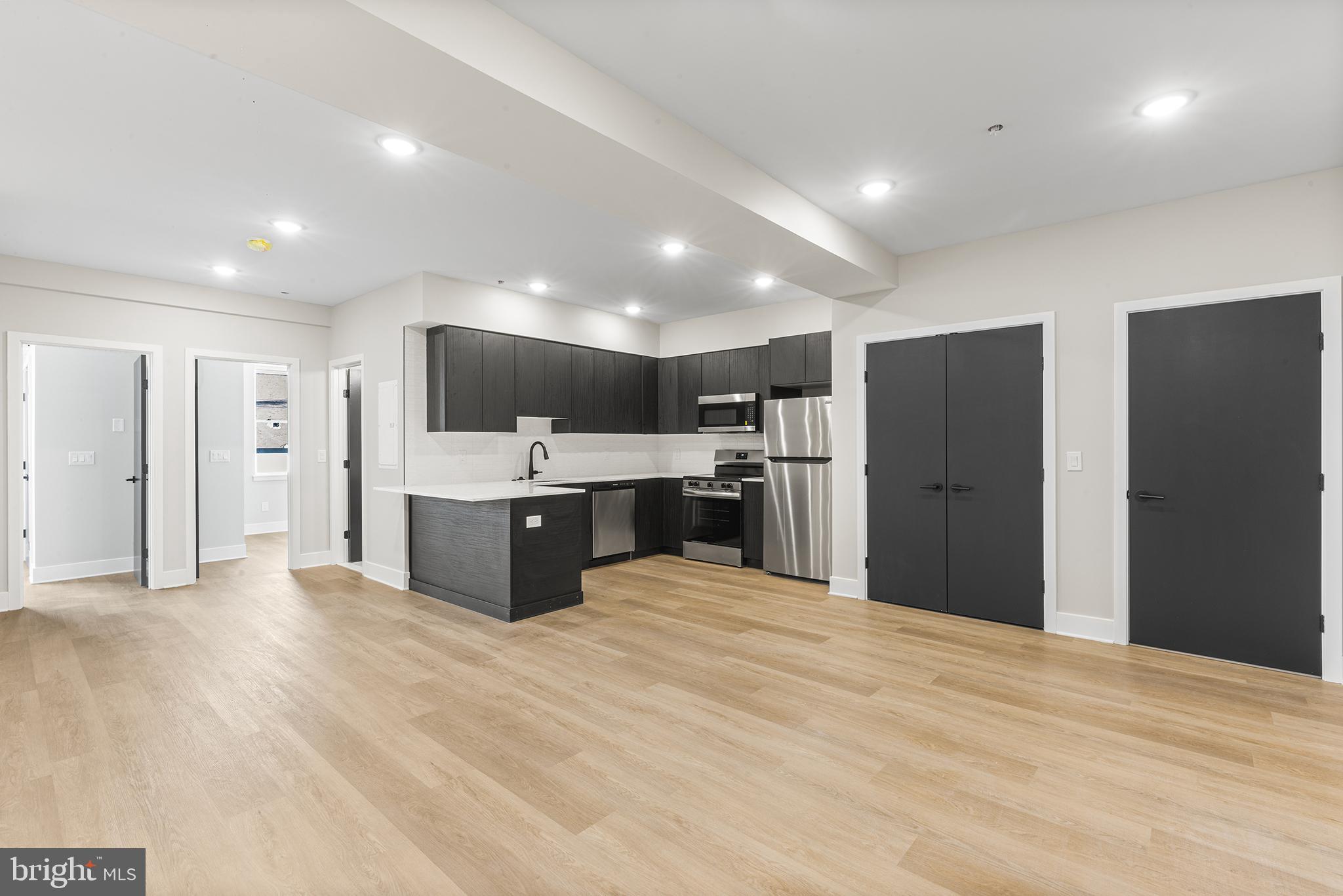1903 Jackson Street, Unit 1 Philadelphia, PA 19145 - Photo 3 of 17 a large kitchen with stainless steel appliances kitchen island a large counter top and a sink
