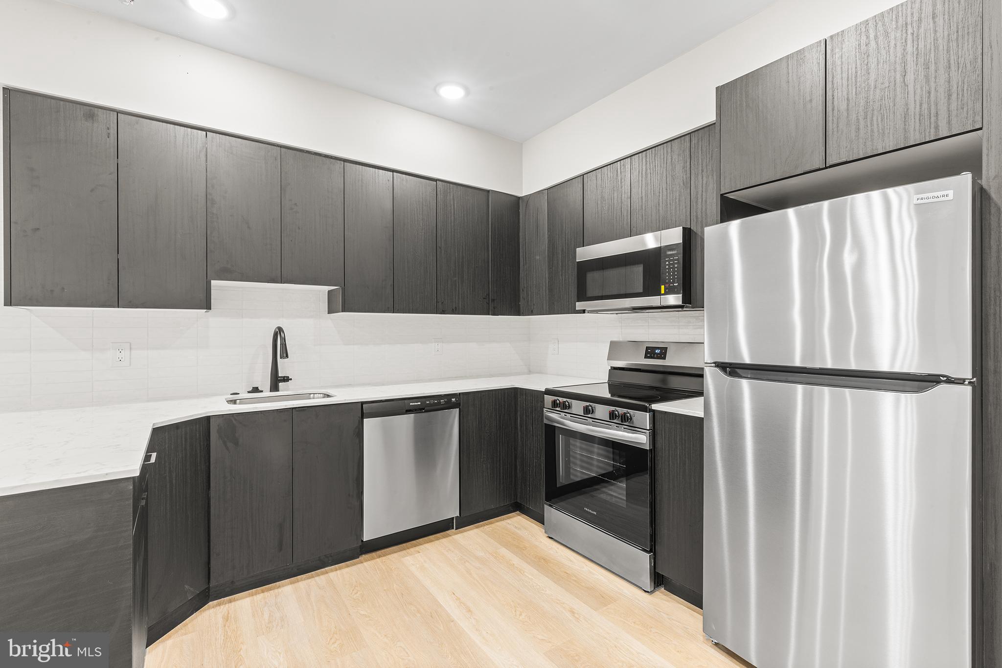 1903 Jackson Street, Unit 1 Philadelphia, PA 19145 - Photo 6 of 17 a kitchen with a refrigerator sink and stove
