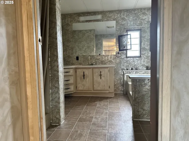a bathroom with a granite countertop sink a mirror and a vanity