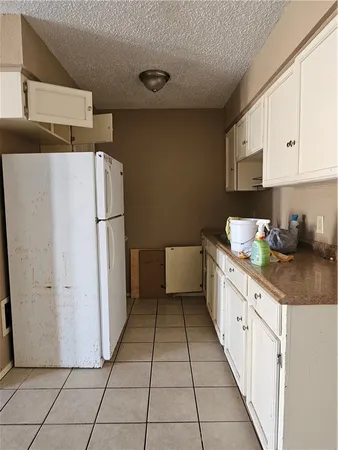 a kitchen with a sink a refrigerator and cabinets