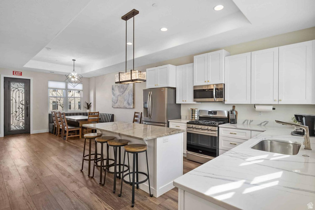 4311 Canterbury Road, Unit F2 Hurricane, UT 84737 - Photo 3 of 18 Open-concept kitchen featuring white cabinetry, stainless steel appliances, and two distinct countertop surfaces