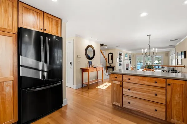 a kitchen with granite countertop a refrigerator cabinets and wooden floor