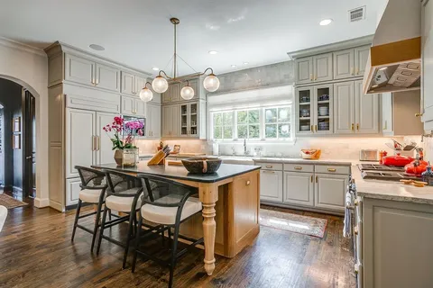 a kitchen that has a lot of cabinets a sink and stainless steel appliances