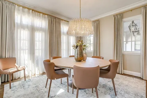 a dining room with furniture a chandelier and wooden floor