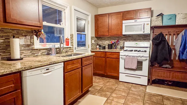 a kitchen with granite countertop a sink stove and cabinets