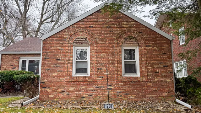 a view of a brick house with large windows