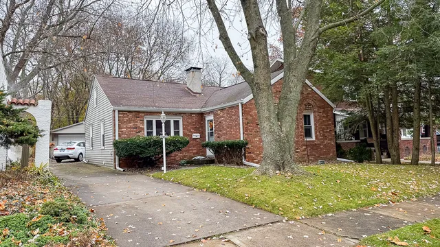 a view of a yard in front of a house with large tree